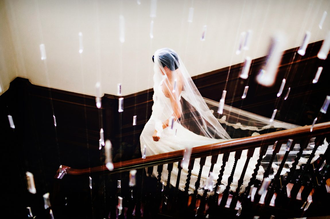 bride walking down stairs with hanging lights